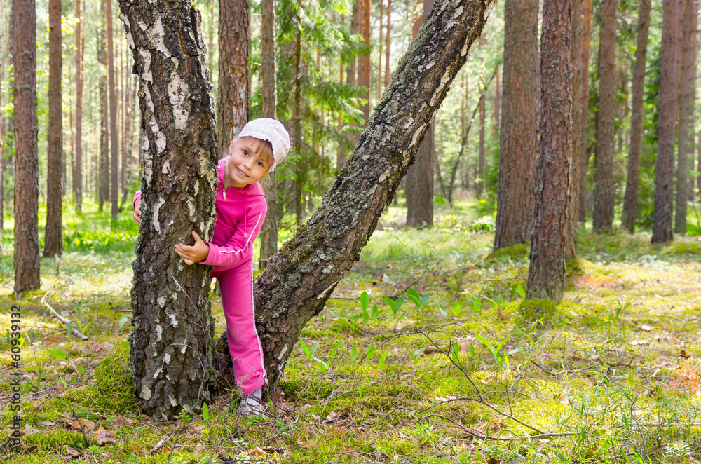 Cheerful girl plays in a forest glade.
