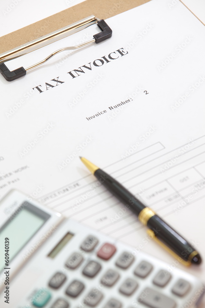 Business document of tax invoice form with pen and calculator Business document of tax invoice form with pen and calculator