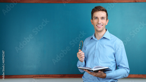 Young teacher near chalkboa...