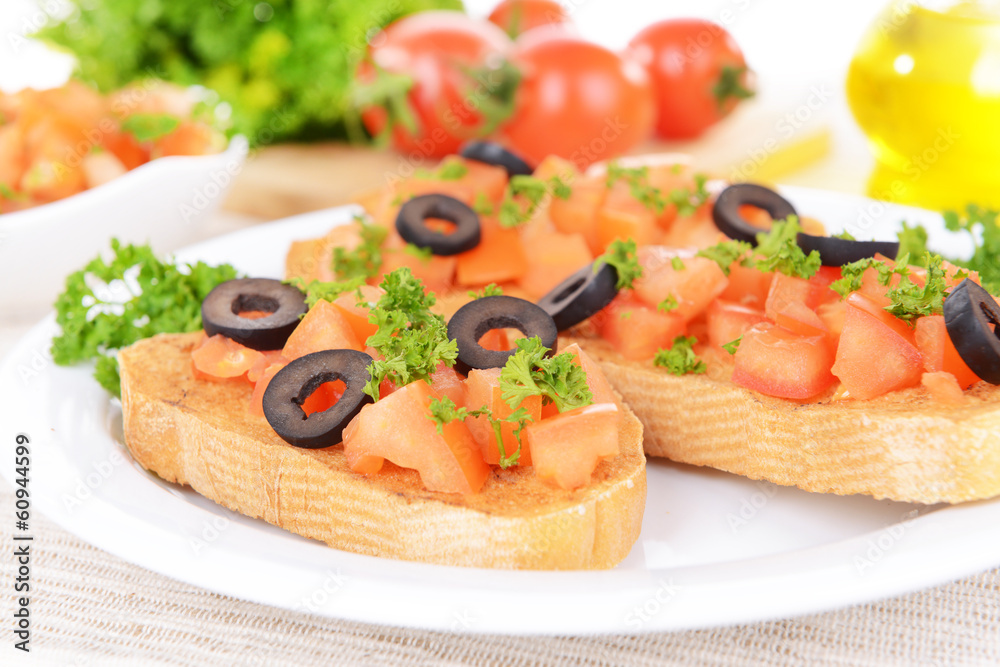 Delicious bruschetta with tomatoes on plate on table close-up Delicious bruschetta with tomatoes on plate on table close-up