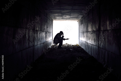 sad man sitting in the tunnel photo