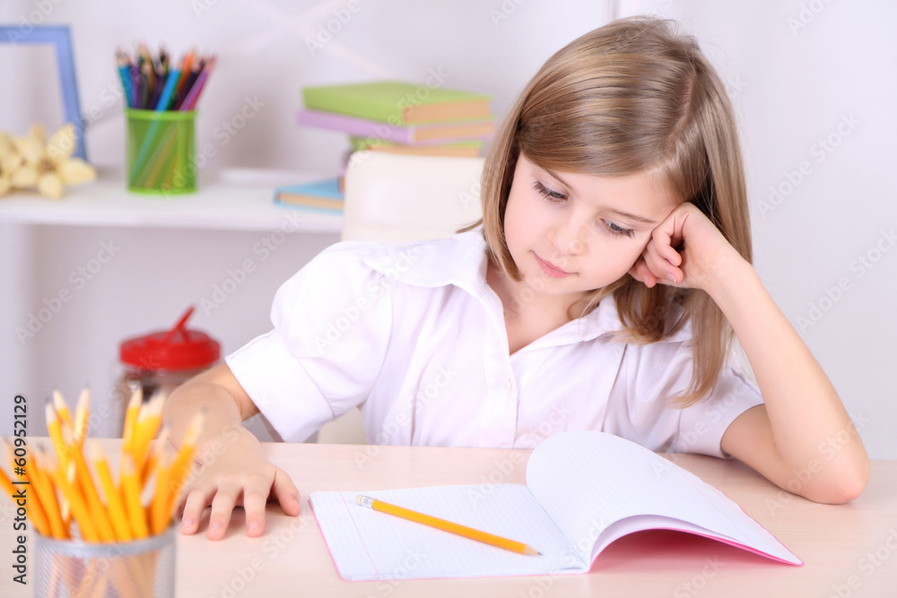 Little girl sitting at desk in room Little girl sitting at desk in room