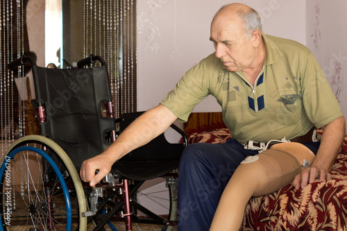 Obraz na płótnie Senior man with an artificial leg and wheelchair w salonie