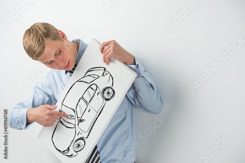 Young businessman holding sign with car sketch. Automobile deale photo