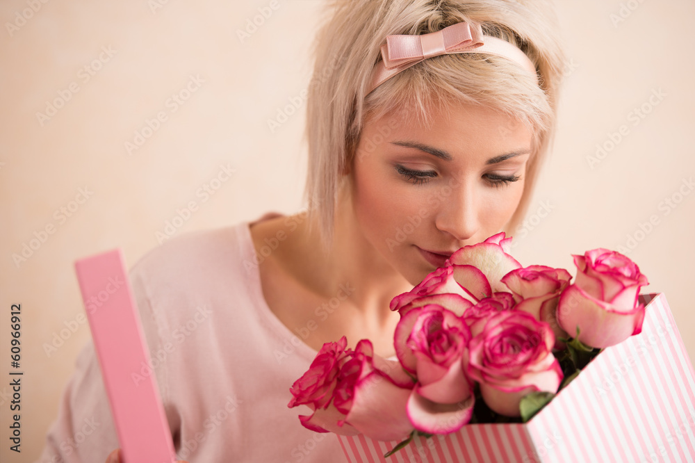 Young beautiful woman holding bow with bouquet of pink roses ins