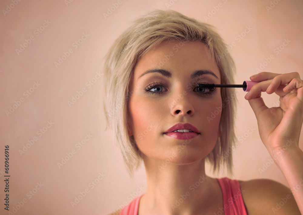 Elegant blonde beauty doing makeup