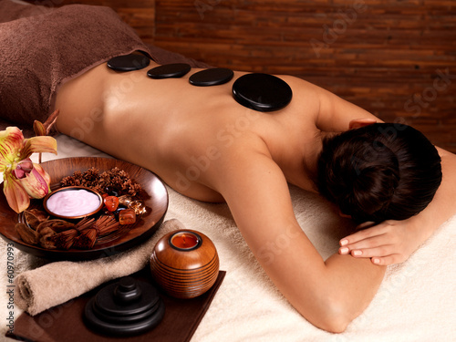 woman having stone massage in spa salon
