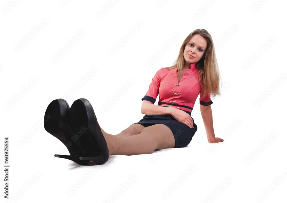 The young blonde in pink dress sits on a floor The young blonde in pink dress sits on a floor