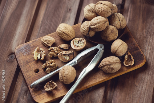 Walnuts and nutcracker on a wooden chopping board