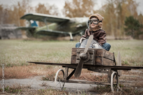 Young boy-pilot in the plane at the airport handmade autumn