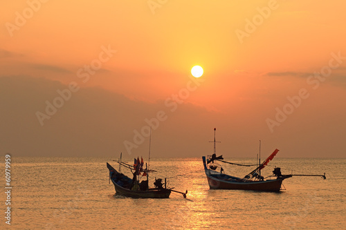 Stunning golden sunset over sea and sky with fishing boat floati photo