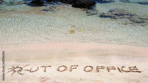 Obraz na płótnie OUT OF OFFICE written on sand on a beautiful beach w salonie