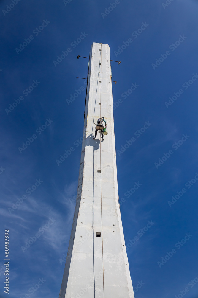 Painter painted the tall building on blue isolated Painter painted the tall building on blue isolated