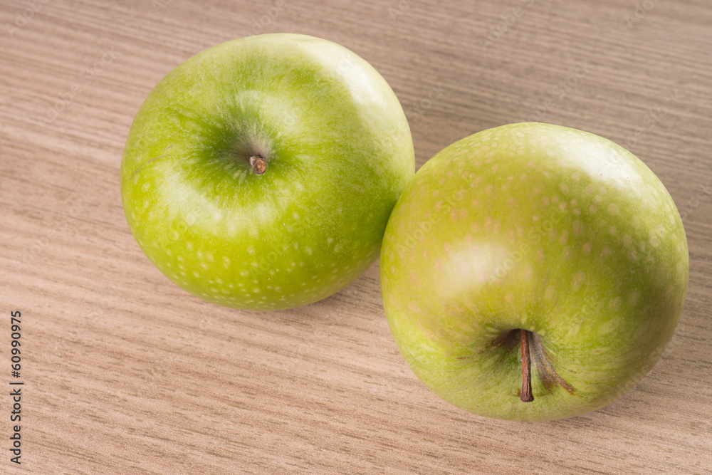 zwei grüne Äpfel auf einem Holzbrett zwei grüne Äpfel auf einem Holzbrett