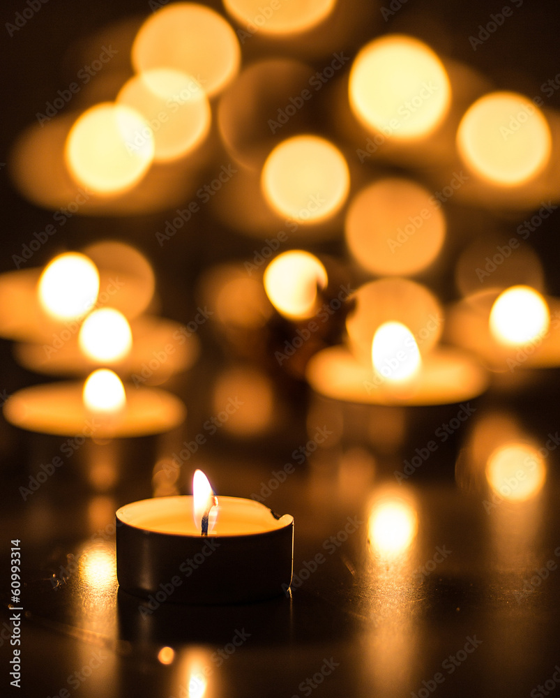 Single candle and many candles with bokeh effect Single candle and many candles with bokeh effect