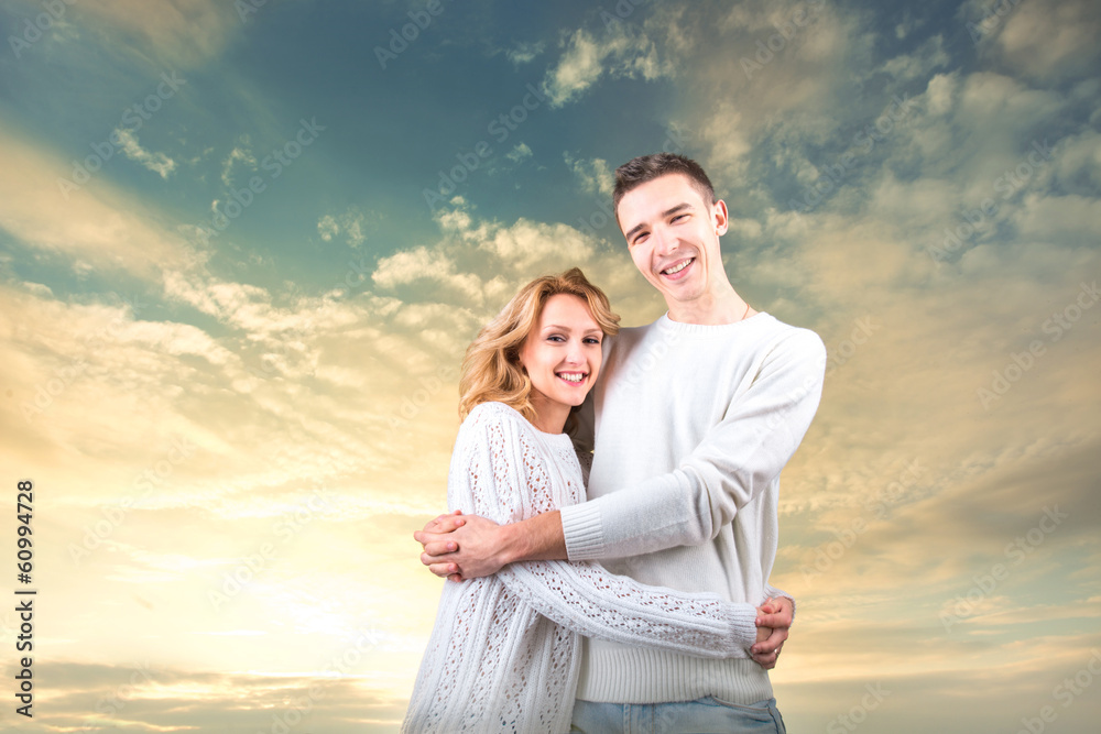 Couple embracing and holding one another under the sunny sky Couple embracing and holding one another under the sunny sky