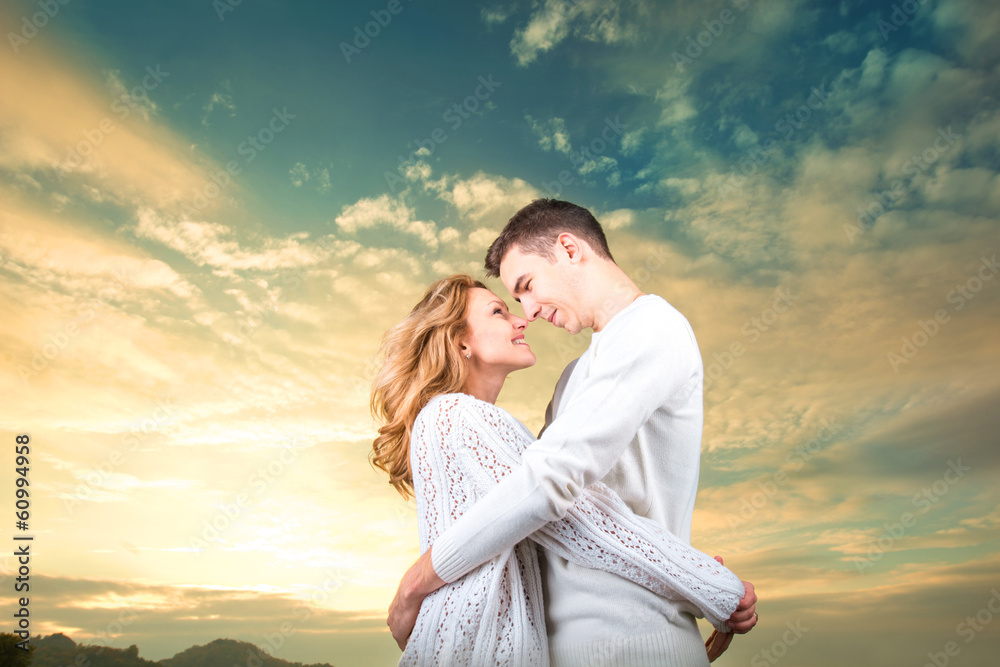Couple embracing and watching one another under the sunny sky Couple embracing and watching one another under the sunny sky