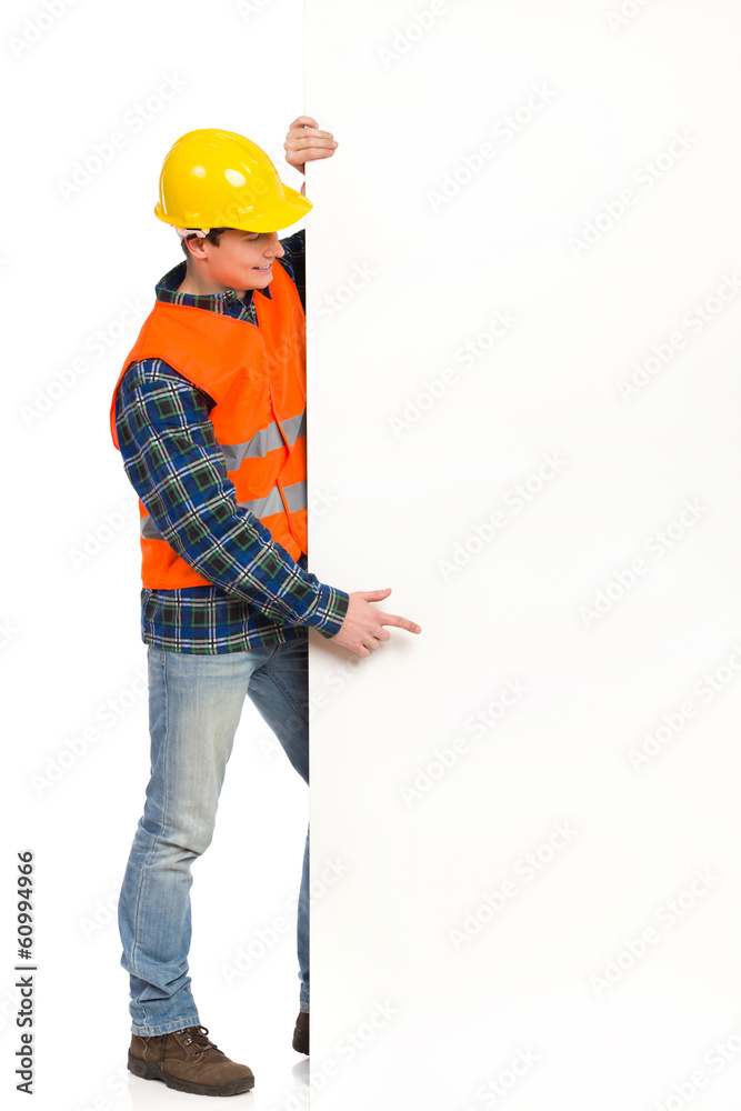 Construction worker pointing at big banner. Construction worker pointing at big banner.
