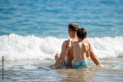 Father and son relaxing in ocean waves