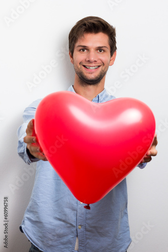 Man holding a red heart balloon © dandaman
