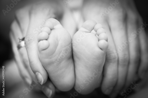 newborn baby feet on female hands