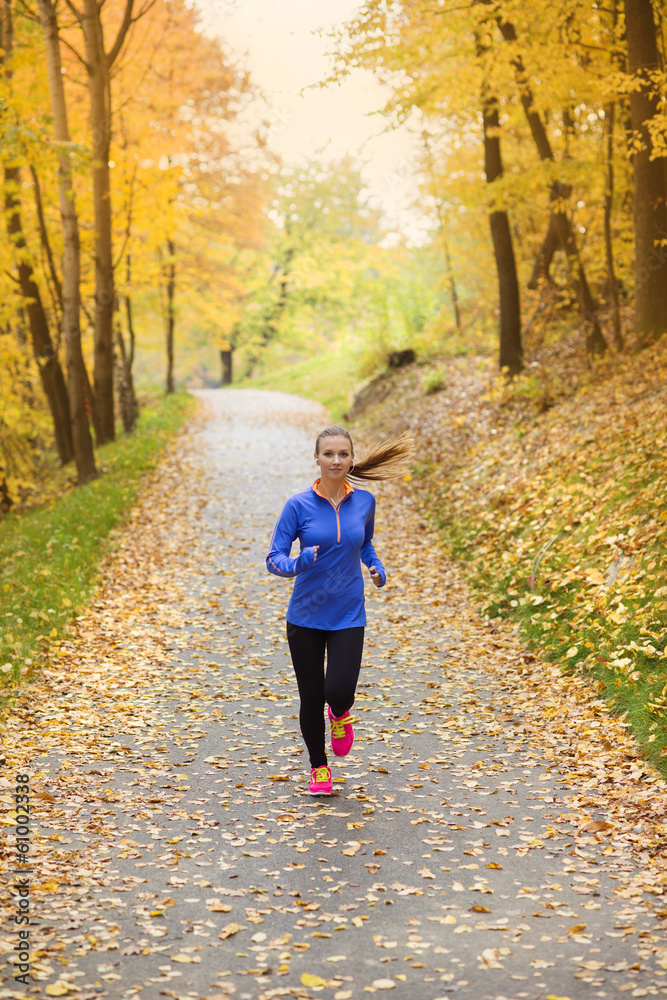 Fototapeta premium Active and sporty woman runner in autumn nature