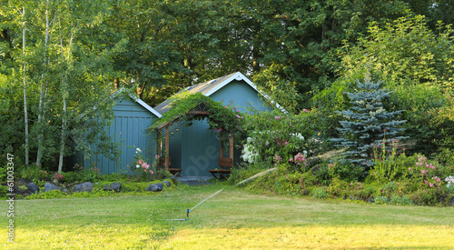 Flourishing farm backyard with sheds and garden house