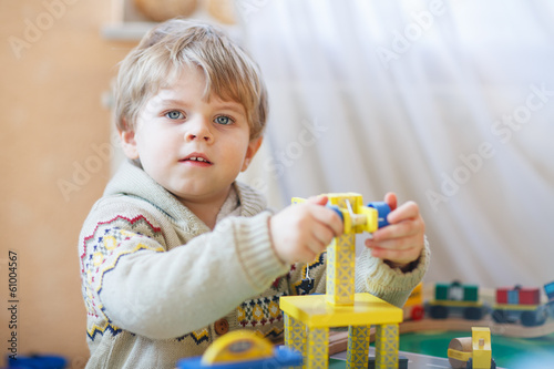 Little toddler boy playing with wooden toy, indoors