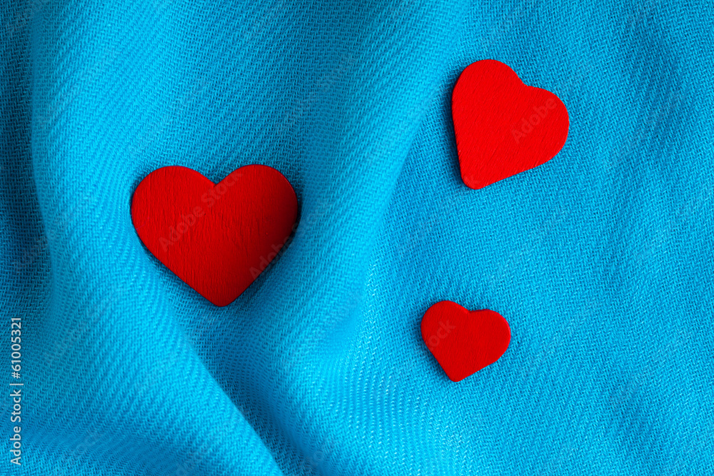Valentine's day background. Red hearts on blue folds cloth