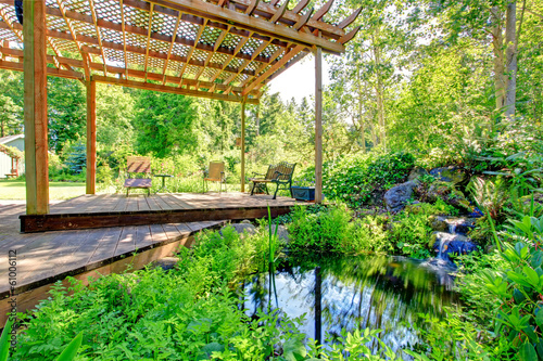 Picturesque backyard farm garden with small pond and patio area photo