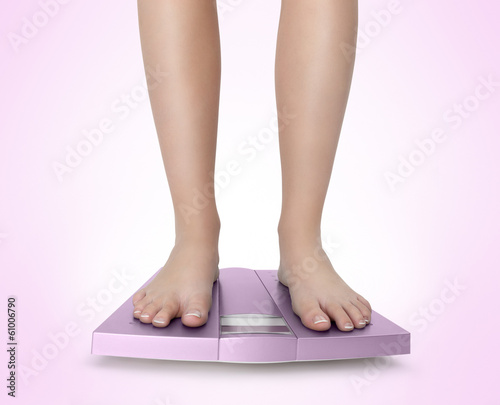 Barefoot woman on pink scale diet