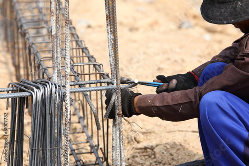worker bending steel rod for construction job