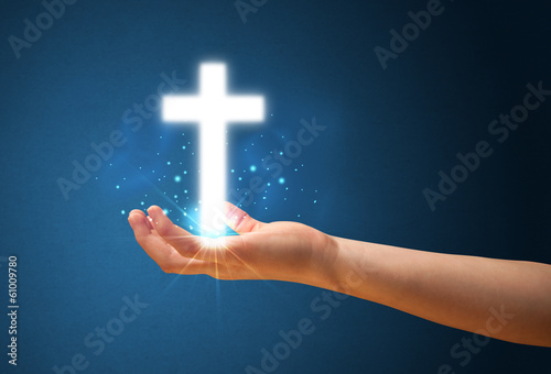 Glowing cross in the hand of a woman
