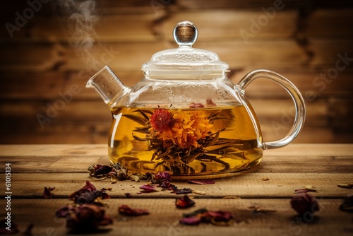Glass teapot with blooming tea flower inside 