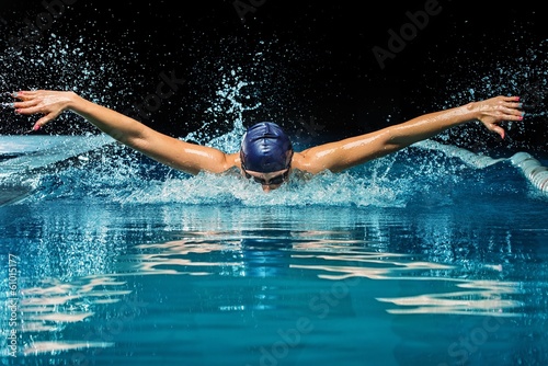 Young woman in blue cap and swimming suit in pool