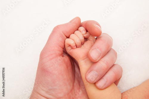 holding a hand of the newborn child