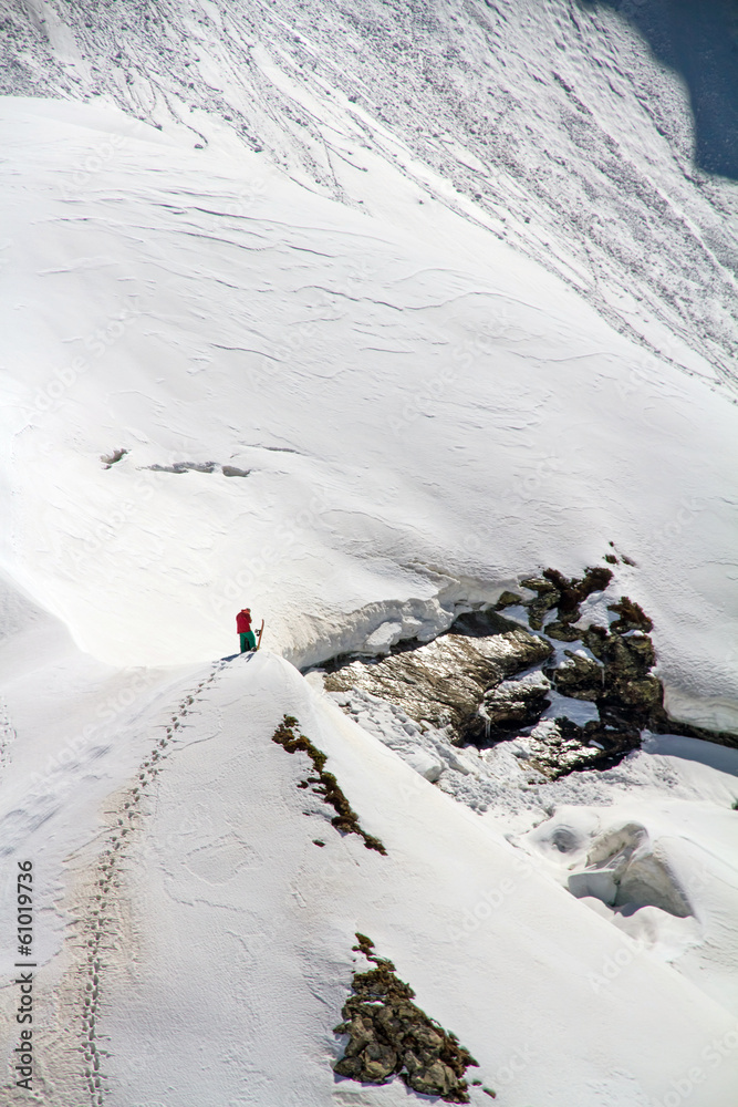 Fototapeta premium Skier climbing a snowy mountain