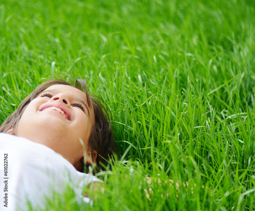 Happy little boy enjoying on grass field and dreaming Happy little boy enjoying on grass field and dreaming