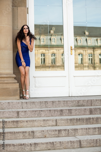 junge attraktive frau im blauem kleid auf einer treppe