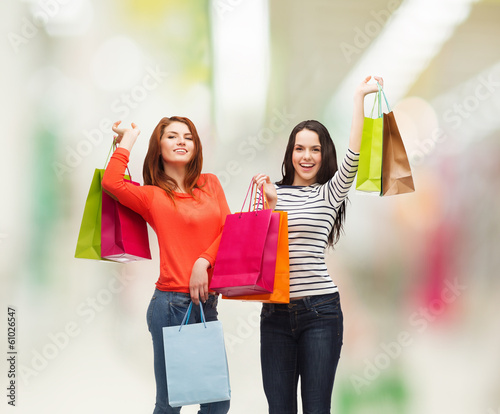 two smiling teenage girls with shopping bags