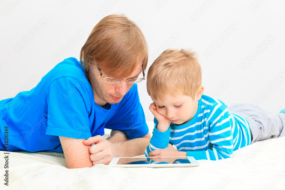 father and son with touch pad at home father and son with touch pad at home