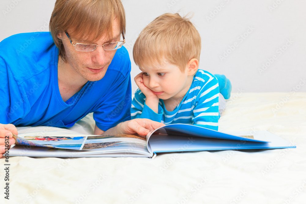 father and son looking at family photo album father and son looking at family photo album