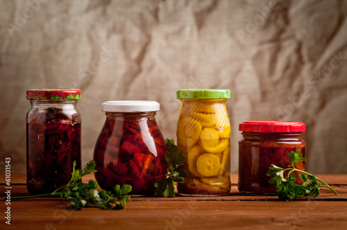 Composition with jars of pickled vegetables. Marinated food.