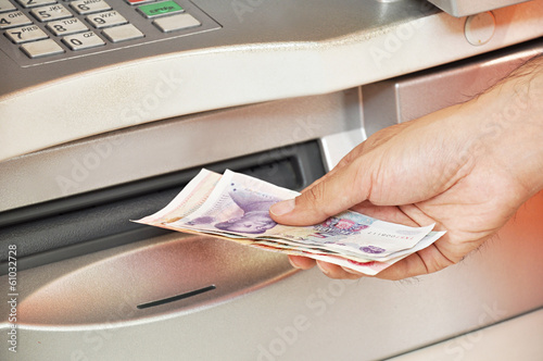 Hand taking money from ATM