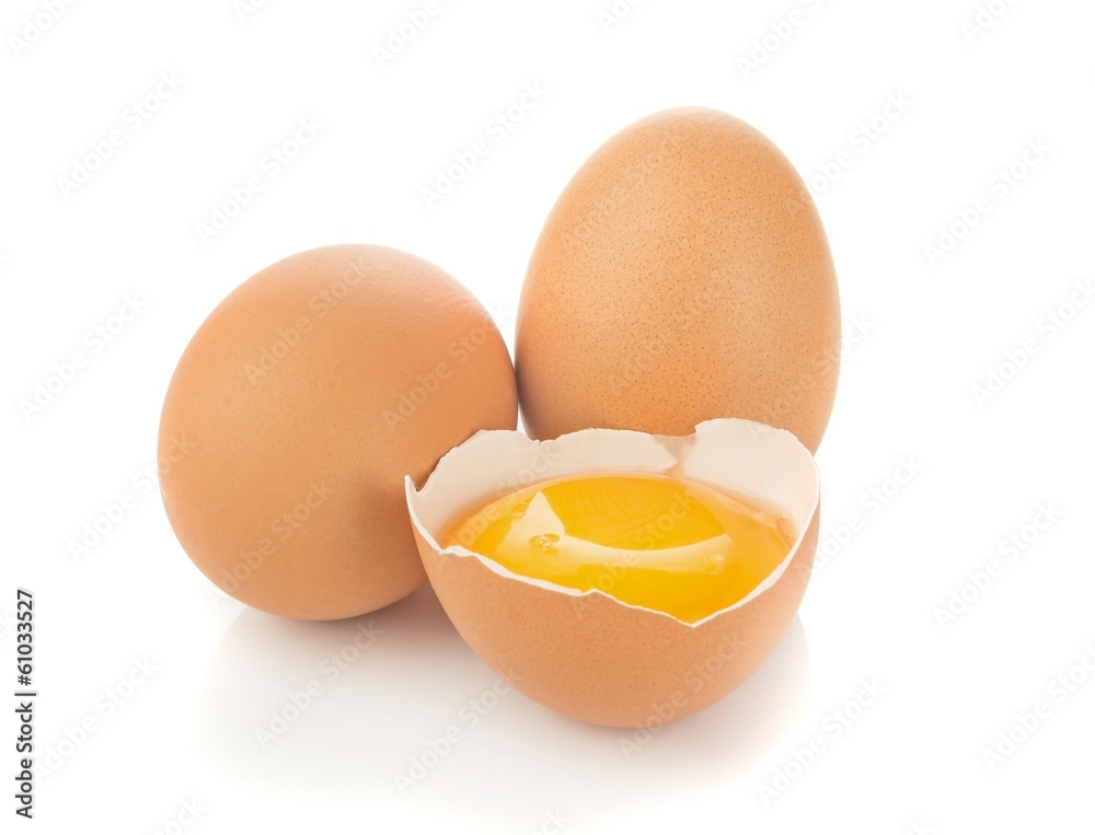 A separated egg yolk and eggs on a white background A separated egg yolk and eggs on a white background