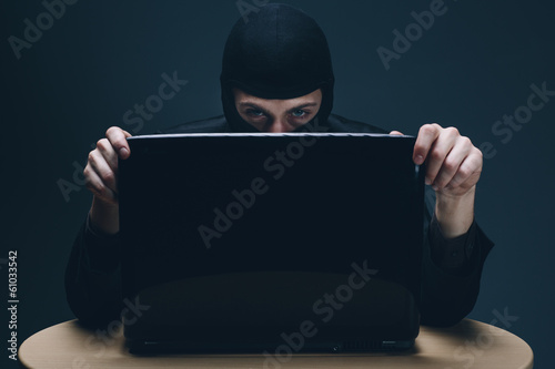Hacker stealing data off a laptop computer