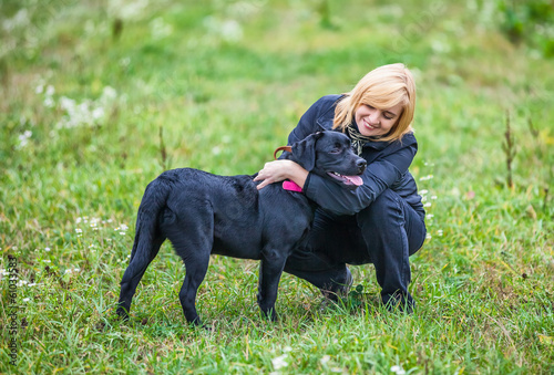 beautiful young woman playing with dog