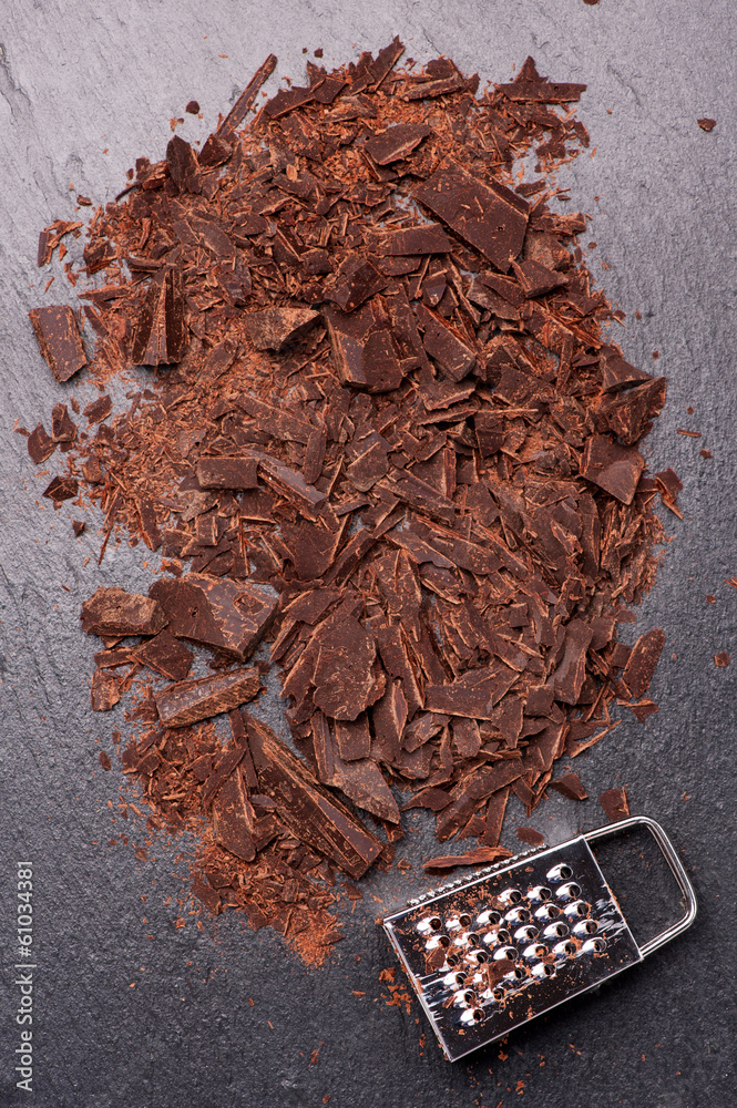 Fototapeta Сhocolate pieces and grated chocolate on dark background
