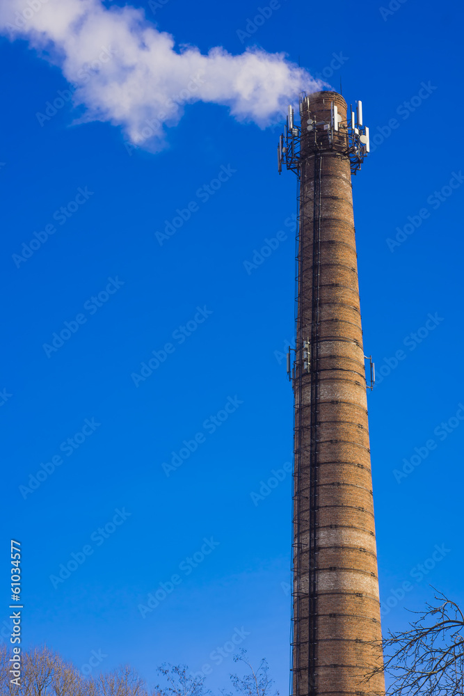 Smoking brick tower with mobile antenna on top Smoking brick tower with mobile antenna on top