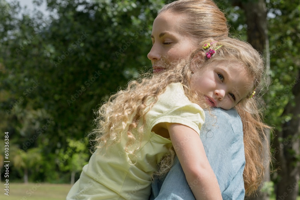 Obraz premium Mother carrying daughter at park